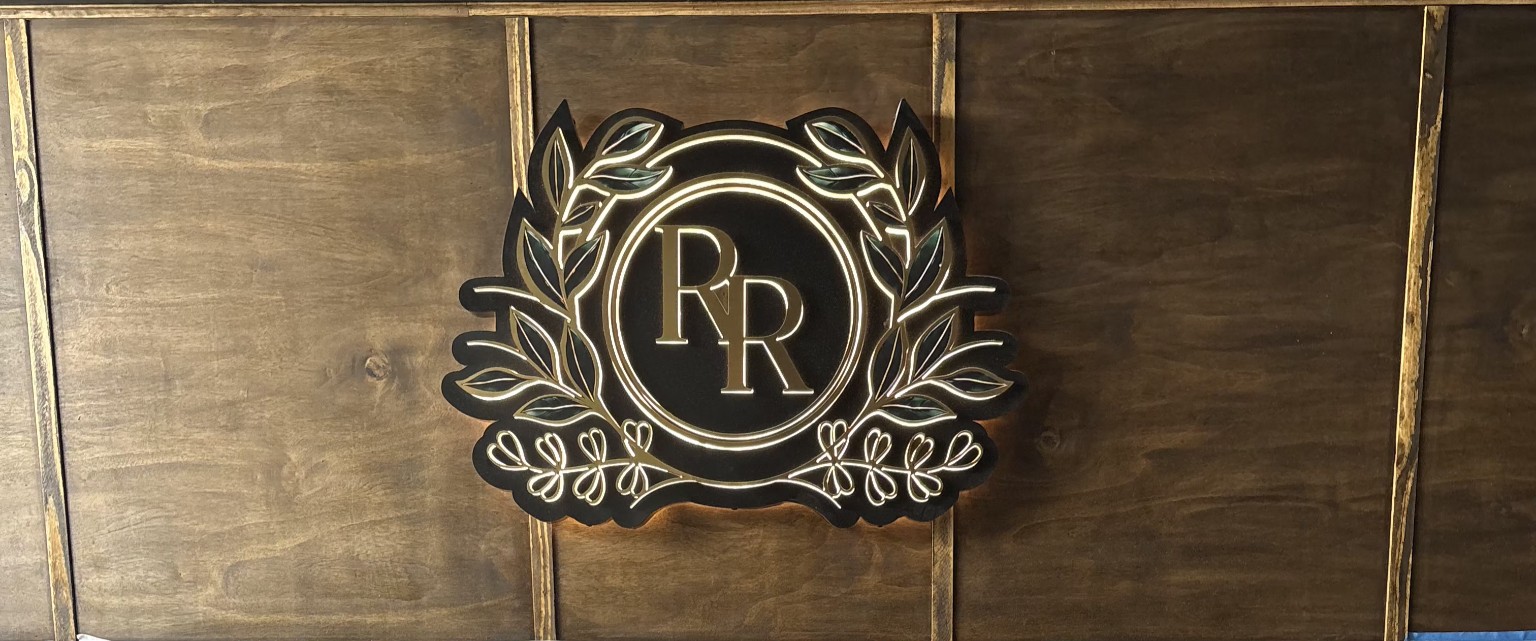 The Reserve Room RR crest with gold laurel mounted on a walnut wall